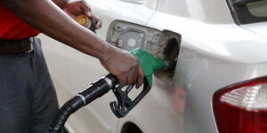 An undated image of a petrol station attendant pumping fuel into a car.