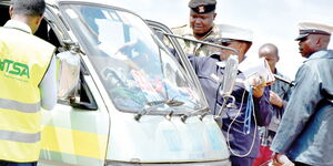 NTSA officials accompanied by police inspect a matatu in Nairobi in December 2019