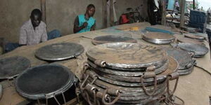 Workers from the Jua Kali sector working to manufacture metallic pans