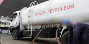 A fuel tanker getting fixed at a petrol station. 