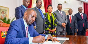 President William Ruto signs documents into law accompanied by DP Rigathi Gachagua and other leaders