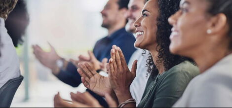 Employees clapping during a past presentation