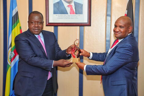 Cabinet Secretary Dr Fred Matiang'i receiving an award from KRA boss James Mburu on Wednesday, July 14, 2021