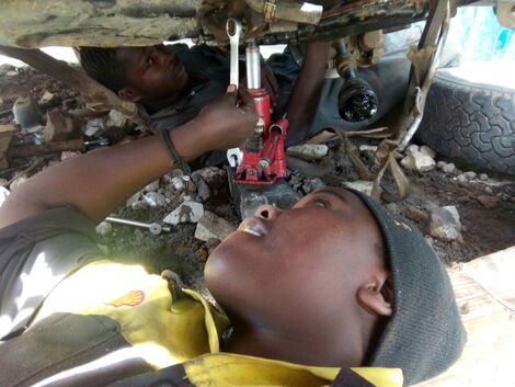 A female mechanic working on a car in a Nairobi garage