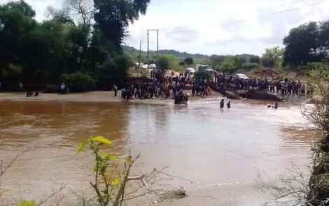 Mwingi residents mill around the accident scene where a bus drowned with 30 wedding guests on board at Enziu River in Mwingi on Saturday, December 4, 2021. 
