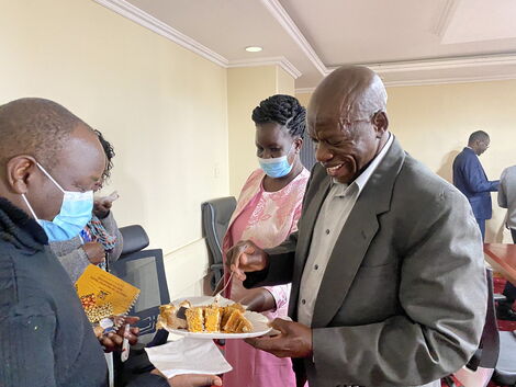 Photo of Ambasu serving cake to attendees at David Osiany's boardroom in Nairobi taken on June 25, 2021.