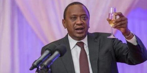President Uhuru Kenyatta holds a glass of champagne during a past event