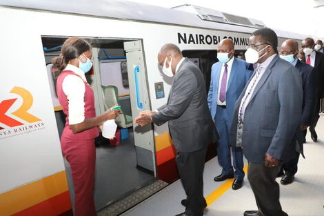 Transport CS James Macharia (second left) sanitises his hands while preparing to board a train on Monday, December 7, 2020.