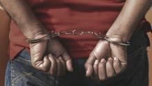 An image of a suspect in handcuffs after being arrested
