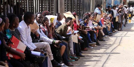 Youth queue outside County Hall, Nairobi with their certificates.