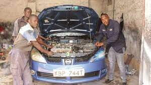 Mechanics working on a car in a Nairobi city garage.