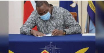 President Uhuru Kenyatta signs a bill into law in December 2020.