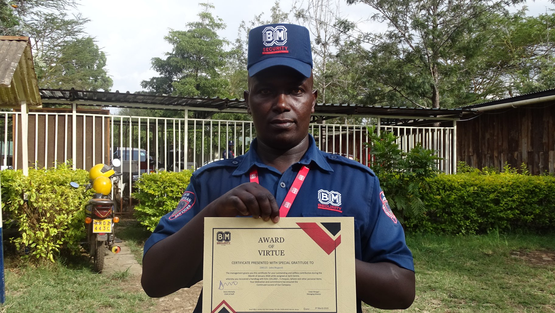 Security Guard Joseph Mugendi poses with a certificate after being awarded on March 17, 2020