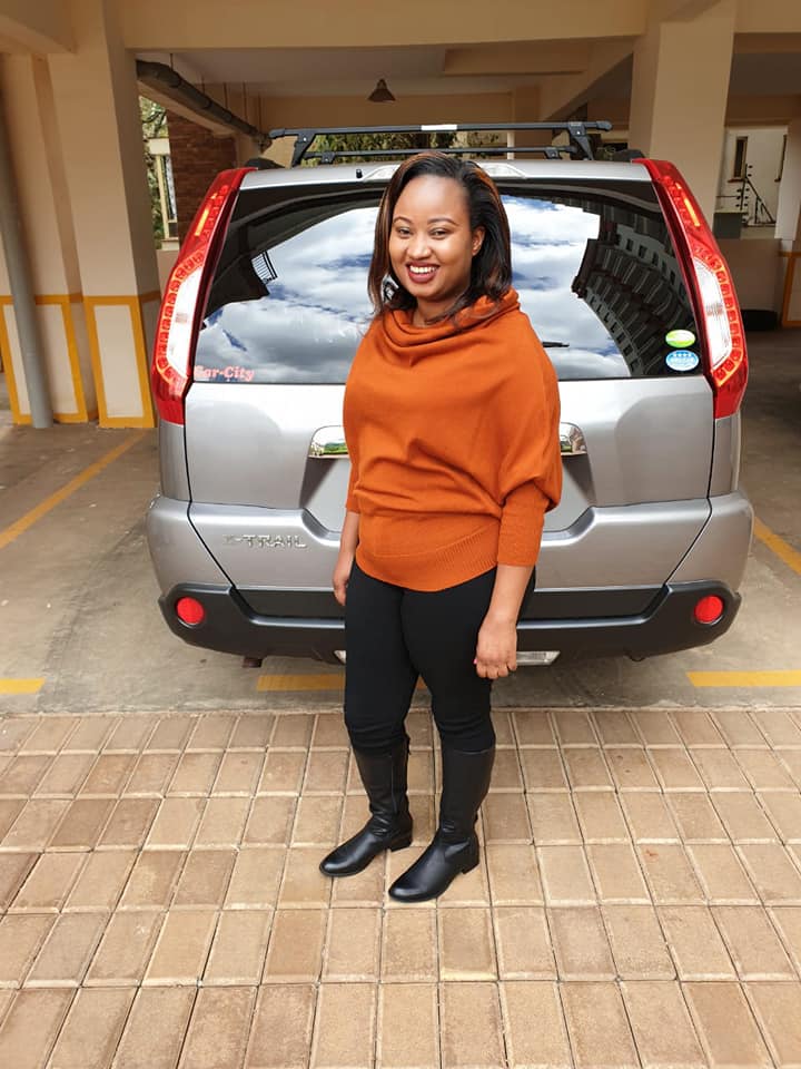 Betty Musambi posses for a photo next to her new car that she was gifted for her birthday.