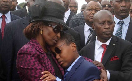 Catherine Wahome, the widow of Nyeri Governor Wahome Gakuru, consoles her son during Gakuru's burial.