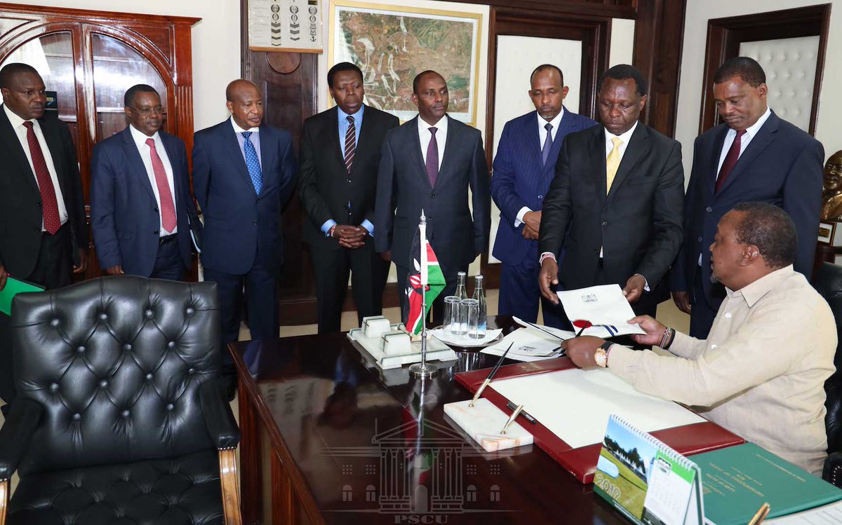 President Uhuru Kenyatta signs the Division of Revenue Bill into law on Tuesday, September 17, while Speaker Justin Muturi and other government leaders look on.