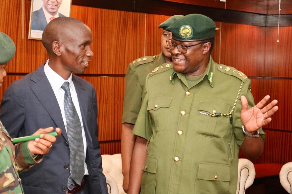 Eliud Kipchoge chats with a Kenya Forest Services (KFS) official after landing in Mombasa on October 19, 2019.