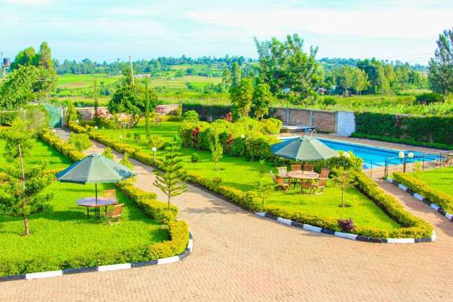 Akothee's compound with well manicured lawn and gazebos for resting.