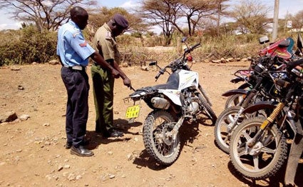 Police officers assess the motorbike that Ngaremara Senior Chief Stephen Mwangola was riding when he was hit and killed by a lorry at Kambi Garba area on Isiolo-Moyale highway on August 30, 2019.