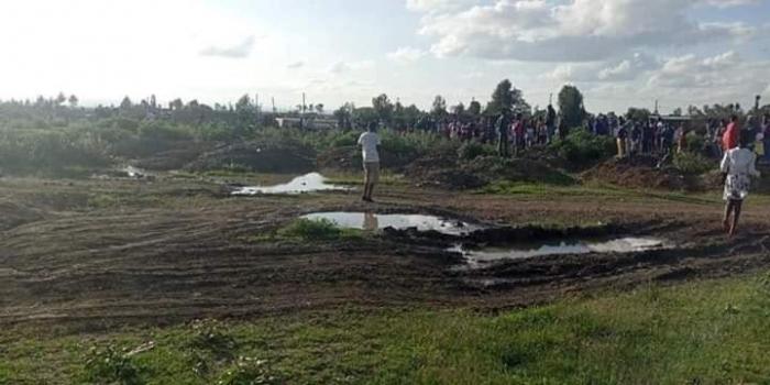 Members of the public gather around the scene where three bodies were discovered on Saturday, November 16.
