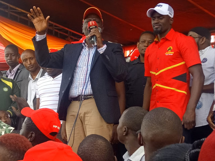 DP Ruto flanked by Jubilee candidate McDonald Mariga addressing the crowd in Kibra on Sunday, October 27.