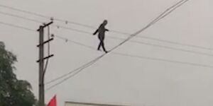 An image of a silhouette walking along the power transmission lines.