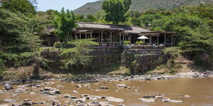 A side image of Olonana Sanctuary adjacent to a river that is filled with hippos.