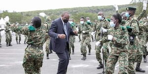 Former President Uhuru Kenyatta dancing with NYS graduates during their pass-out parade in Gilgil on December 2, 2021. 