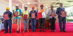 President William Ruto (centre) holds the Affordable Housing Act, alongside Lands CS Alice Wahome (second from right) and Attorney General Justin Muturi at State House on March 19, 2024.