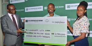 Vincent Marangu - Director, Co-operatives Banking at Co-op Bank hands the Ksh2.75 million prize money dummy cheque to CEO Chamasoft Ltd Martin Njuguna and Business Development Manager Lucy Muthoni
