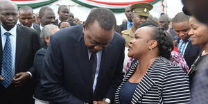 President Uhuru Kenyatta speaking to Kirinyaga Woman Representative Wangui Ngirici during a past event. 