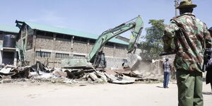 A bulldozer demolishes a building in Lanet, Nakuru County