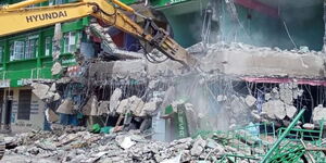 A bulldozer pulling down a house