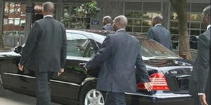 A file image of a VIP guest being escorted by security officers.