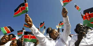 A group of women holding replicas of the Kenyan flag