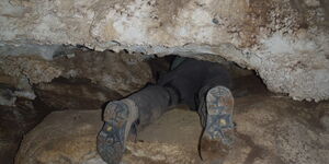 A man crawling into a cave