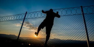 A person jumping over a fence