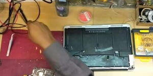 A person repairing a damaged laptop