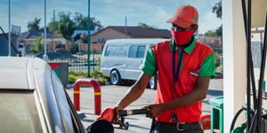 A petrol station attendant fueling a vehicle