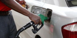 A petrol station attendant pumping fuel into a car.