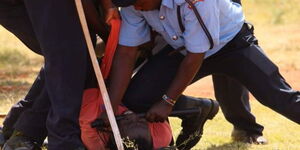 A photo a man pinned down by four police officers at Kasarani stadium on February 15, 2023...jpg