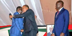 A photo of President William Ruto (far right) looking on as former President Uhuru Kenyatta and Azimio leader Raila Odinga exchange pleasantries.