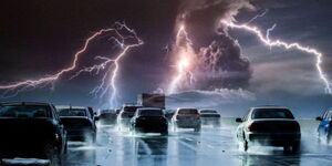 A photo of vehicles driving through a thunderstorm