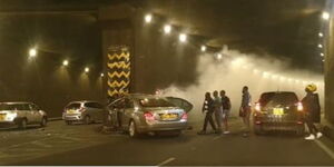 A photo of witnesses trying to assist a man out of the vehicle that crashed along Prof. Wangari Maathai Road tunnel along Thika Road on March 12, 2023.