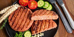 A plate of plant-based meat and some vegetables