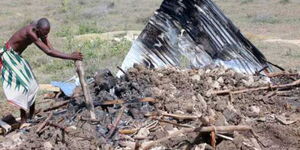 A resident goes through remnants of his house at Nguu Tatu village in Kisauni, after police demolished and burnt it during eviction exercise in November 2015.