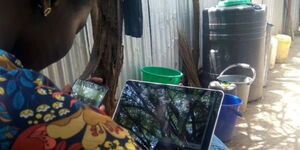 A woman using a laptop at the Kakuma refugee camp.