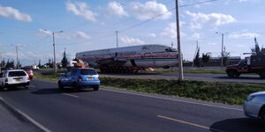 An airplane fuselage being transported along a highway in Kenya.