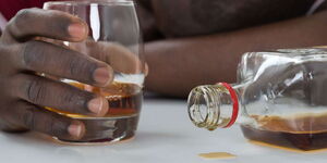 File image of a man holding a glass of alcohol