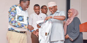 Garissa Governor Ali Korane hands a garment to Devolution Cabinet Secretary Eugene Wamalwa when he visited Garissa on February 27, 2020